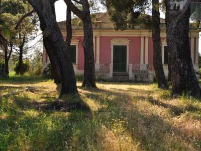 Il bianco delle lesene e il verde scuro delle persiane spiccano sulle sue graziose pareti rosa